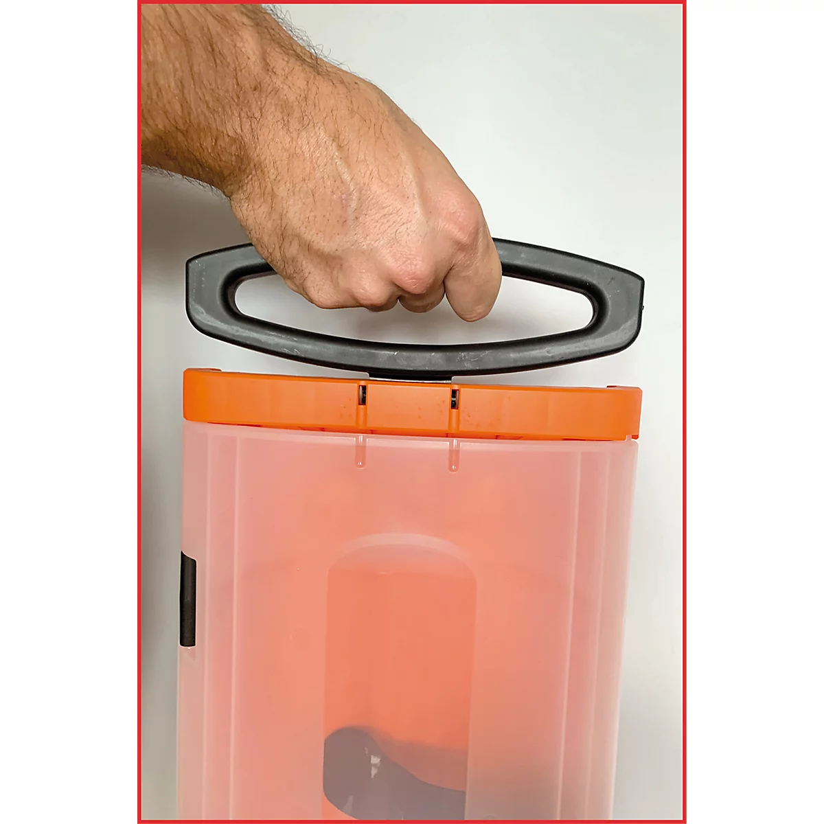 Een hand houdt een zwarte handgreep boven een oranje doos. De handgreep is aan de doos bevestigd.